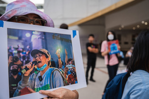 A participant holds a portrait of a detained activist during a “People’s Amnesty” vigil. People gathered outside Bangkok Art and Culture Centre for a candlelight vigil titled “Light Up Hope for the People’s Amnesty.” Organized ahead of a parliamentary debate on the 16 July 2025, the event featured personal testimonies, portraits of 50 political detainees, and a red rose display reading “Amnesty 112.” Participants called for the passage of a comprehensive amnesty bill covering cases under Section 112 of the Thai Criminal Code.