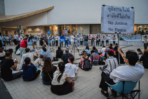 A participant holds a placard reading “No Justice, No Peace” as others display portraits of activists during the “People’s Amnesty” vigil. People gathered outside Bangkok Art and Culture Centre for a candlelight vigil titled “Light Up Hope for the People’s Amnesty.” Organized ahead of a parliamentary debate on the 16 July 2025, the event featured personal testimonies, portraits of 50 political detainees, and a red rose display reading “Amnesty 112.” Participants called for the passage of a comprehensive amnesty bill covering cases under Section 112 of the Thai Criminal Code.