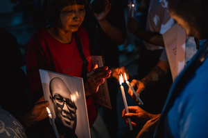 Participants light candles while holding a portrait of a detained activist during the “People’s Amnesty” vigil. People gathered outside Bangkok Art and Culture Centre for a candlelight vigil titled “Light Up Hope for the People’s Amnesty.” Organized ahead of a parliamentary debate on the 16 July 2025, the event featured personal testimonies, portraits of 50 political detainees, and a red rose display reading “Amnesty 112.” Participants called for the passage of a comprehensive amnesty bill covering cases under Section 112 of the Thai Criminal Code.