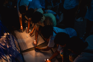 Participants light candles together during the “People’s Amnesty” vigil. People gathered outside Bangkok Art and Culture Centre for a candlelight vigil titled “Light Up Hope for the People’s Amnesty.” Organized ahead of a parliamentary debate on the 16 July 2025, the event featured personal testimonies, portraits of 50 political detainees, and a red rose display reading “Amnesty 112.” Participants called for the passage of a comprehensive amnesty bill covering cases under Section 112 of the Thai Criminal Code.