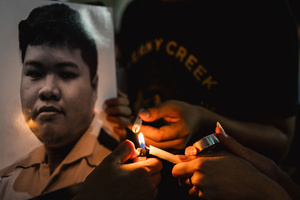 Participants light candles beside a portrait of a detained activist during the “People’s Amnesty” vigil. People gathered outside Bangkok Art and Culture Centre for a candlelight vigil titled “Light Up Hope for the People’s Amnesty.” Organized ahead of a parliamentary debate on the 16 July 2025, the event featured personal testimonies, portraits of 50 political detainees, and a red rose display reading “Amnesty 112.” Participants called for the passage of a comprehensive amnesty bill covering cases under Section 112 of the Thai Criminal Code.