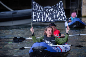 Extinction Rebellion activists seated in kayaks hold large banners, expressing their opinion during an attempt to block the path of Luxury Ocean liner the "Celebrity Eclipse" from docking at the Passages Terminal. A little before sunrise, climate activists from Extinction Rebellion, Netherlands attempted to block the path of Luxury Ocean liner the ‘Celebrity Eclipse’ from docking at the Passages Terminal in Amsterdam. The ‘Celebrity Eclipse’ is operated by Celebrity Cruises, a subsidiary of Royal Caribbean Group. The activist numbered 30 in all, with the majority in 2-person kayaks. ‘Cruise ships are floating environmental disasters. They should not be allowed in Dutch waters. We demand strict and binding national and international environmental standards and regulations, as well as strict enforcement and sanctions policy.