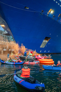 Extinction Rebellion climate activists in kayaks, attempt to block the path of Luxury Ocean liner the "Celebrity Eclipse" from docking at the Passages Terminal. A little before sunrise, climate activists from Extinction Rebellion, Netherlands attempted to block the path of Luxury Ocean liner the ‘Celebrity Eclipse’ from docking at the Passages Terminal in Amsterdam. The ‘Celebrity Eclipse’ is operated by Celebrity Cruises, a subsidiary of Royal Caribbean Group. The activists numbered 30 in all, with the majority in 2-person kayaks stating that "Cruise ships are floating environmental disasters. They should not be allowed in Dutch waters. We demand strict and binding national and international environmental standards and regulations, as well as strict enforcement and sanctions policy."