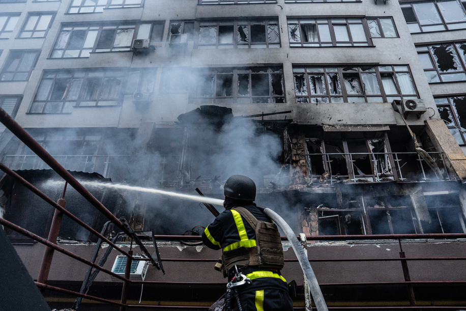 A Ukrainian firefighter extinguishes fire in apartment block damaged in overnight drone attack.