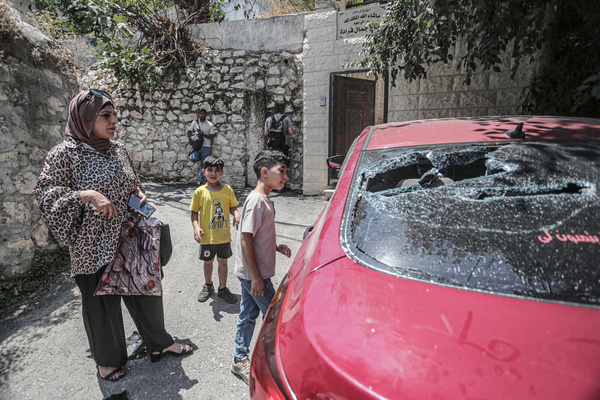 Palestinians inspect a damaged car, after it was ambushed by Israeli forces and all its passengers were arrested, near the city of Nablus in the northern occupied West Bank.
