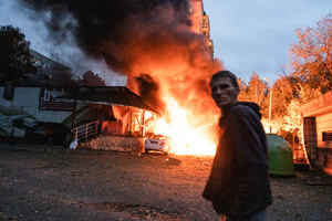 A resident walks past a fire following the Russian missile attack. On July 31, 2025, a massive Russian missile and drone attack on Kyiv left at least 16 people dead, including two children, and caused widespread destruction. Ukrainian forces intercepted most of the 309 drones and eight cruise missiles, but some struck residential areas, collapsing a section of a nine-story building. Over 100 buildings were damaged across 27 locations, including schools, hospitals, and homes.