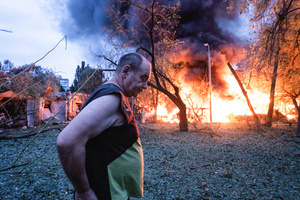 A resident walks past a fire following the Russian missile attack. On July 31, 2025, a massive Russian missile and drone attack on Kyiv left at least 16 people dead, including two children, and caused widespread destruction. Ukrainian forces intercepted most of the 309 drones and eight cruise missiles, but some struck residential areas, collapsing a section of a nine-story building. Over 100 buildings were damaged across 27 locations, including schools, hospitals, and homes.