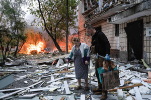 A man assists an elderly resident in evacuating from her damaged home following the Russian missile attack. On July 31, 2025, a massive Russian missile and drone attack on Kyiv left at least 16 people dead, including two children, and caused widespread destruction. Ukrainian forces intercepted most of the 309 drones and eight cruise missiles, but some struck residential areas, collapsing a section of a nine-story building. Over 100 buildings were damaged across 27 locations, including schools, hospitals, and homes.