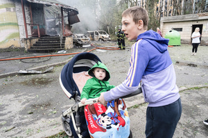A big brother pushes the stroller of his sibling outside their damaged residence following the Russian missile attack. On July 31, 2025, a massive Russian missile and drone attack on Kyiv left at least 16 people dead, including two children, and caused widespread destruction. Ukrainian forces intercepted most of the 309 drones and eight cruise missiles, but some struck residential areas, collapsing a section of a nine-story building. Over 100 buildings were damaged across 27 locations, including schools, hospitals, and homes.