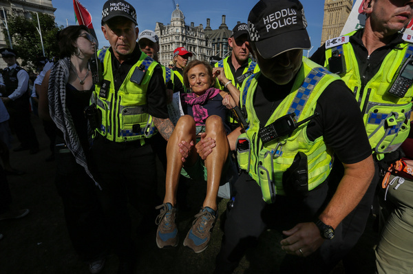 A protester is carried away after being arrested for showing support for a proscribed organisation during the demonstration. Following the Home Secretary's order to proscribe Palestine Action as a terrorist organisation, over 500 supporters organised by Defend Our Juriesgatheredr to sit down in Parliament Square holding signs saying, "I oppose genocide. I support Palestine Action" and dared the police to arrest them all.