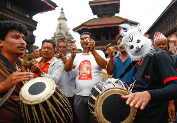 Devotees play traditional drums during the Gai Jatra festival procession. The Newar community observes the festival to honor family members who passed away in the past year.