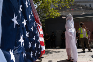 "The Ghost of Due Process" seen in front of the American flag. Demonstrators of the group "Extinction Rebellion" protest outside of the Immigration Court at 26 Federal Plaza against ICE detainments and inhumane holding conditions.