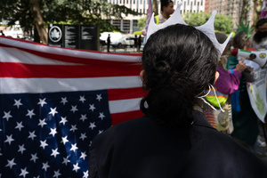 Demonstrators seen with an American flag during the protest. Demonstrators of the group "Extinction Rebellion" protest outside of the Immigration Court at 26 Federal Plaza against ICE detainments and inhumane holding conditions.