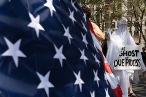 "The Ghost of Due Process" seen in front of the American flag. Demonstrators of the group "Extinction Rebellion" protest outside of the Immigration Court at 26 Federal Plaza against ICE detainments and inhumane holding conditions.