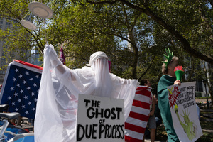 A woman dressed as "The Ghost of Due Process" marches beside demonstrators. Demonstrators of the group "Extinction Rebellion" protest outside of the Immigration Court at 26 Federal Plaza against ICE detainments and inhumane holding conditions.