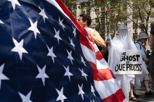"The Ghost of Due Process" seen in front of the American flag. Demonstrators of the group "Extinction Rebellion" protest outside of the Immigration Court at 26 Federal Plaza against ICE detainments and inhumane holding conditions.