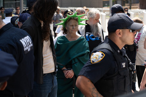 A woman dressed as the Statue of Liberty seen arrested by NYPD. Demonstrators of the group "Extinction Rebellion" protest outside of the Immigration Court at 26 Federal Plaza against ICE detainments and inhumane holding conditions.