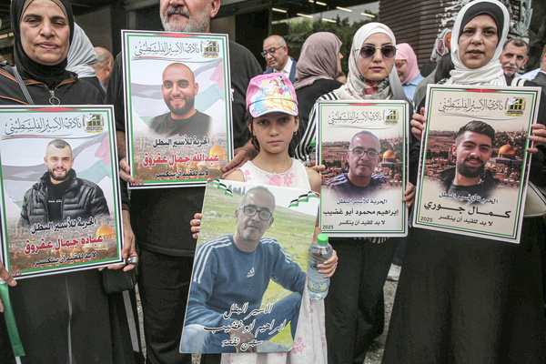 Families of Palestinian prisoners hold portraits of their imprisoned relatives during a solidarity rally demanding a prisoner exchange agreement between the Israeli government and Hamas.