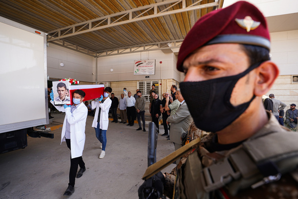 Staff members carry a coffin containing the remains of a Yazidi man at the Forensic Medicine Department in Mosul, northern Iraq, during preparations to transport them to Sinjar for handover to their families. The 22 victims, killed in 2014 during the Yazidi genocide by ISIS in Sinjar, were exhumed from a mass grave and identified through DNA testing in Baghdad. This marks the eighth group of victims released by the Mosul Forensic Medicine Department.
