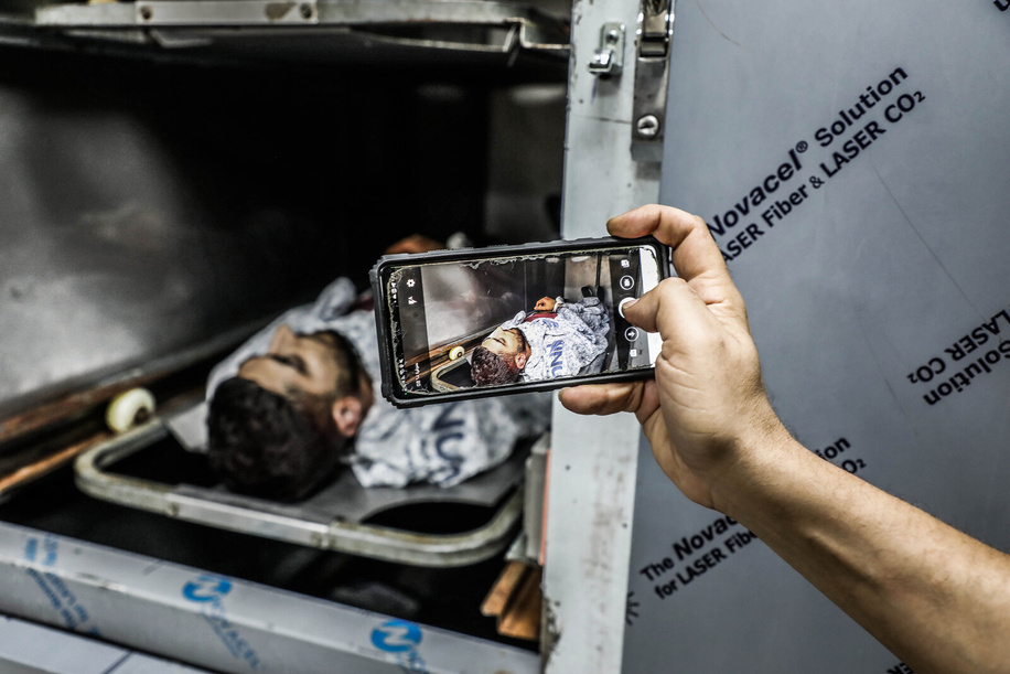 (EDITOR'S NOTE: Image depicts death) 
A man photographs the body of a Palestinian killed by Jewish settlers in the village of Aqraba, south of Nablus, in the northern occupied West Bank. One Palestinian was killed and others were injured during the clashes.