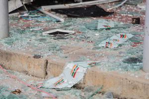 Shattered glass and broken signage litter the ground in front of the damaged 7-Eleven at a PTT station in Kantharalak, weeks after a Cambodian border clash rocket strike. Three weeks after the Cambodian border clash, Kantharalak still bears the scars, including the July 24 rocket strike on a PTT station that killed eight civilians and injured several others. The station remains closed, leaving more than 50 employees in limbo as compensation issues remain unresolved.