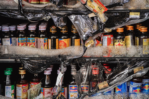 Melted refrigerator shelves and burnt beverage bottles inside the damaged 7-Eleven at a PTT station in Kantharalak, weeks after a Cambodian border clash rocket strike. Three weeks after the Cambodian border clash, Kantharalak still bears the scars, including the July 24 rocket strike on a PTT station that killed eight civilians and injured several others. The station remains closed, leaving more than 50 employees in limbo as compensation issues remain unresolved.