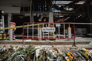 Flowers were laid in front of the destroyed 7-Eleven at a PTT station in Kantharalak, honoring the victims of the July 24 rocket strike during the Thai-Cambodian border clash. Three weeks after the Cambodian border clash, Kantharalak still bears the scars, including the July 24 rocket strike on a PTT station that killed eight civilians and injured several others. The station remains closed, leaving more than 50 employees in limbo as compensation issues remain unresolved.