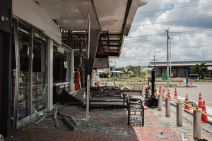 Shattered glass and debris outside the damaged 7-Eleven at a PTT station in Kantharalak, weeks after a rocket strike during the Thai-Cambodian border clash. Three weeks after the Cambodian border clash, Kantharalak still bears the scars, including the July 24 rocket strike on a PTT station that killed eight civilians and injured several others. The station remains closed, leaving more than 50 employees in limbo as compensation issues remain unresolved.