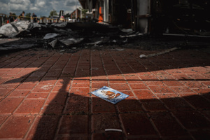 A discarded photograph of a Buddhist monk lies on the floor of the destroyed 7-Eleven at a PTT station in Kantharalak, weeks after the Thai-Cambodian border clash rocket strike. Three weeks after the Cambodian border clash, Kantharalak still bears the scars, including the July 24 rocket strike on a PTT station that killed eight civilians and injured several others. The station remains closed, leaving more than 50 employees in limbo as compensation issues remain unresolved.