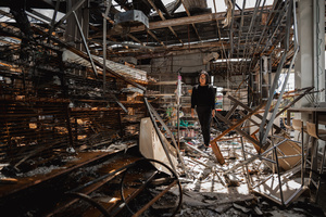 Kamonrat Phonsettalert, owner of the PTT station in Kantharalak, stands in front of the destroyed 7-Eleven located on her premises, weeks after a rocket strike during the Thai-Cambodian border clash killed seven and injured one. Three weeks after the Cambodian border clash, Kantharalak still bears the scars, including the July 24 rocket strike on a PTT station that killed eight civilians and injured several others. The station remains closed, leaving more than 50 employees in limbo as compensation issues remain unresolved.