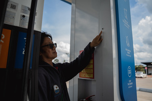 Auan, assistant to Kamonrat Phonsettalert, points to a rocket impact mark on a gas pump at the PTT station in Kantharalak, weeks after the Thai-Cambodian border clash. Three weeks after the Cambodian border clash, Kantharalak still bears the scars, including the July 24 rocket strike on a PTT station that killed eight civilians and injured several others. The station remains closed, leaving more than 50 employees in limbo as compensation issues remain unresolved.