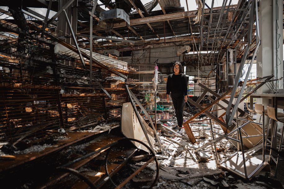 Kamonrat Phonsettalert, owner of the PTT station in Kantharalak, stands in front of the destroyed 7-Eleven located on her premises, weeks after a rocket strike during the Thai-Cambodian border clash killed seven and injured one. Three weeks after the Cambodian border clash, Kantharalak still bears the scars, including the July 24 rocket strike on a PTT station that killed eight civilians and injured several others. The station remains closed, leaving more than 50 employees in limbo as compensation issues remain unresolved.