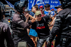 An Israeli police officer holds a protester during the demonstration. Demonstrators call on Israeli Prime Minister Benjamin Netanyahu to end the war in Gaza and to release all 50 Israeli hostages held by Hamas since October 7, 2023. On what was the biggest day of national mobilization, hundreds of thousands of people poured into the streets around the country to demand a Hostage release deal and an end to the war in Gaza.