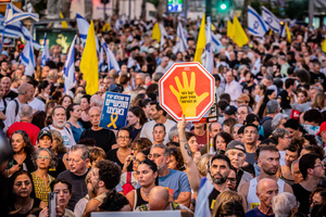 An Israeli man holds up a stop sign during the demonstration. Demonstrators call on Israeli Prime Minister Benjamin Netanyahu to end the war in Gaza and to release all 50 Israeli hostages held by Hamas since October 7, 2023. On what was the biggest day of national mobilization, hundreds of thousands of people poured into the streets around the country to demand a Hostage release deal and an end to the war in Gaza.