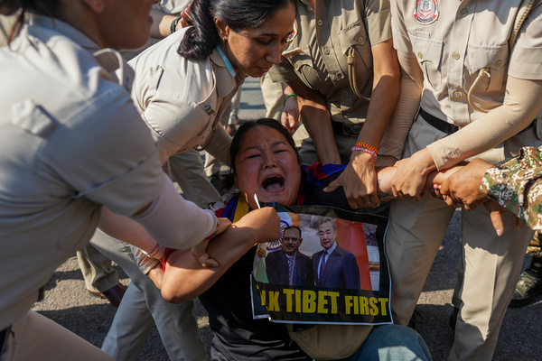 Police personnel detain a member of the Tibetan Youth Congress during a protest against the visit of Chinese Foreign Minister Wang Yi near the Chinese Embassy. Demonstrators waved Tibetan flags and held placards demanding freedom for Tibet, urging the Indian government to raise human rights concerns during bilateral talks.