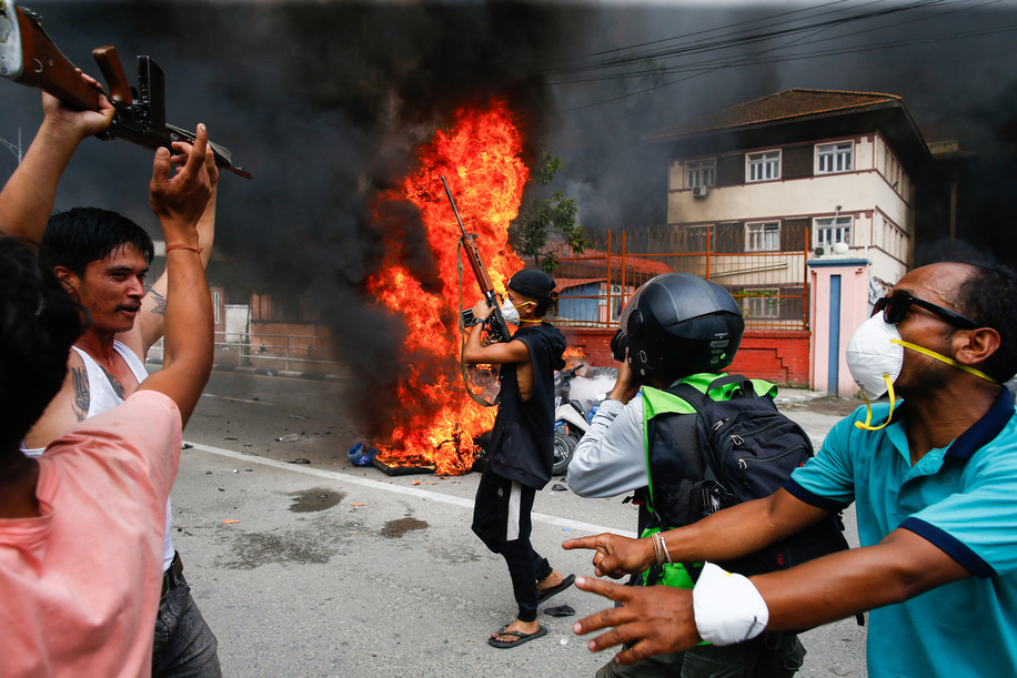 A protester holds a gun before capturing Singha Durbar, which housed the office of the former Prime Minister and other ministries, amid raging Gen Z protests against corruption and the social media crackdown. Prime Minister K.P. Sharma Oli resigned earlier in the day amid intensifying unrest.