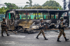 Nepal Army patrols past a burnt vehicle after the Gen Z protests in Kathmandu, Nepal, on Wednesday, September 10, 2025, the third day of an army-imposed curfew. The demonstrations, sparked by anger over corruption, the social media ban, and the killing of more than 19 youths, led to the resignation of Prime Minister K.P. Sharma Oli. The country remains under army control amid escalating unrest.