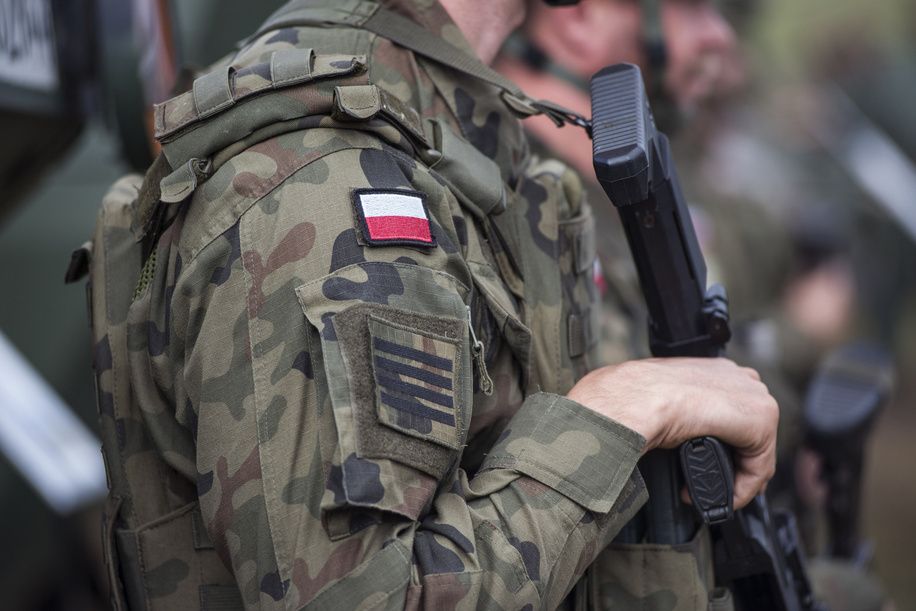 A Polish serviceman with a machine gun and the Polish flag on his arm seen during military exercises of Poland and NATO allied countries. Poland and NATO allies held military exercises at a training ground as part of Iron Defender-25 (?elazny Obro?ca-25), the largest and most significant planned event for the Polish Armed Forces. The drills involve land, air, and sea operations conducted by the Land Forces, Air Force, Navy, Special Forces, and Territorial Defense Forces. Around 30,000 soldiers and 600 pieces of equipment are taking part. The exercise aims to test interoperability and readiness for defensive operations in a multi-domain environment. Officials emphasize the drills are defensive but note they coincide with Zapad-25, large-scale Russian-Belarusian war games happening at the same time.