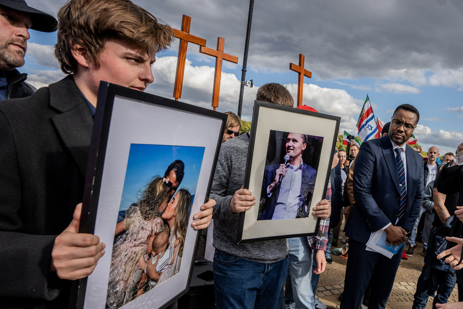 Young British men hold up framed photographs in tribute to the recently-slain Charlie Kirk, with crosses in the background. The ceremony was organized by Turning Point, the American right-wing student pressure group founded by Kirk. Eulogising speakers included Nick Tenconi, leader of UKIP.