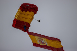 An Air Force paratrooper descends with a Spanish flag to kick off the parade. During the Armed Forces parade on National Day led by King Felipe VI, Queen Letizia, their daughters Leonor de Borbón, Princess of Asturias and Infanta Sofía de Borbón.
