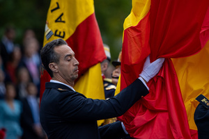 A soldier holds part of a Spanish flag during the flag raising ceremony. During the Armed Forces parade on National Day led by King Felipe VI, Queen Letizia, their daughters Leonor de Borbón, Princess of Asturias and Infanta Sofía de Borbón.