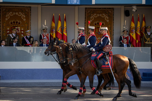A representation of uniformed officers mounted on horseback marches. During the Armed Forces parade on National Day led by King Felipe VI, Queen Letizia, their daughters Leonor de Borbón, Princess of Asturias and Infanta Sofía de Borbón.