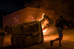 A pro-Palestinian protester is seen throwing trash on burning dumpsters during the demonstration. A nationwide strike was held all over Spain, with demonstration in all the main cities. More than 20.000 of pro-Palestinian protesters marched in Barcelona, with several clashes with police and episodes of looting and burning of dumpsters.