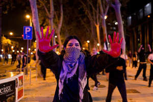A pro-Palestinian protester with her hands painted in red looks toward the police during the demonstration. A nationwide strike was held all over Spain, with demonstration in all the main cities. More than 20.000 of pro-Palestinian protesters marched in Barcelona, with several clashes with police and episodes of looting and burning of dumpsters.