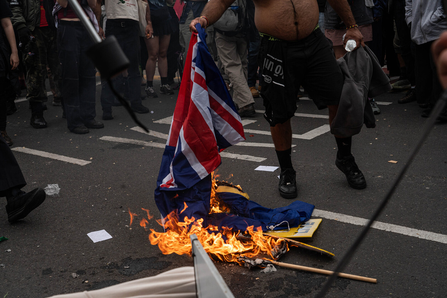 An Australian flag is burned by protesters during the rally. A counter-rally opposing the “March for Australia” rally in Melbourne turned violent as clashes erupted between participants and police. Officers used pepper spray, rubber bullets, and flash bangs to control the crowd after fights broke out, with bins and Australian flags set on fire. Authorities reported one arrest following the unrest.