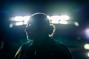 A police officer watches demonstrators in front of the Broadview Immigration Detention Facility. A lawsuit filed October 30, 2025 alleges inhumane, degrading, and humiliating conditions in the facility with a lack of food, water, access to hygiene and medical care, or places to sleep.