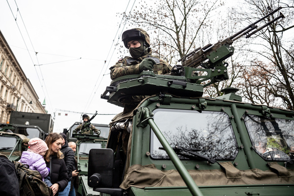 Military men sit in armed vehicles exhibited on the street as families participate in the Independence Day Celebrations in Krakow.