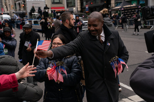 Veterans of the United States Armed Forces hand out American flags during the 106th annual Veterans Day Parade.