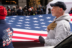Veterans of the United States Armed Forces march while holding a large American flag during the 106th annual Veterans Day Parade.