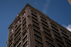 Three American Flags hang from the top floor of a building during the 106th annual Veterans Day Parade.